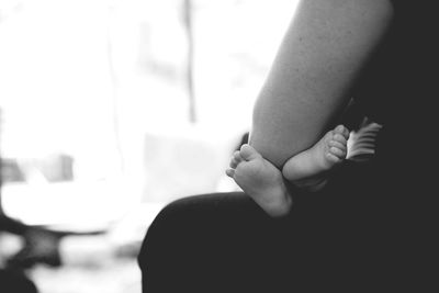 Close-up of hand holding man sitting at home