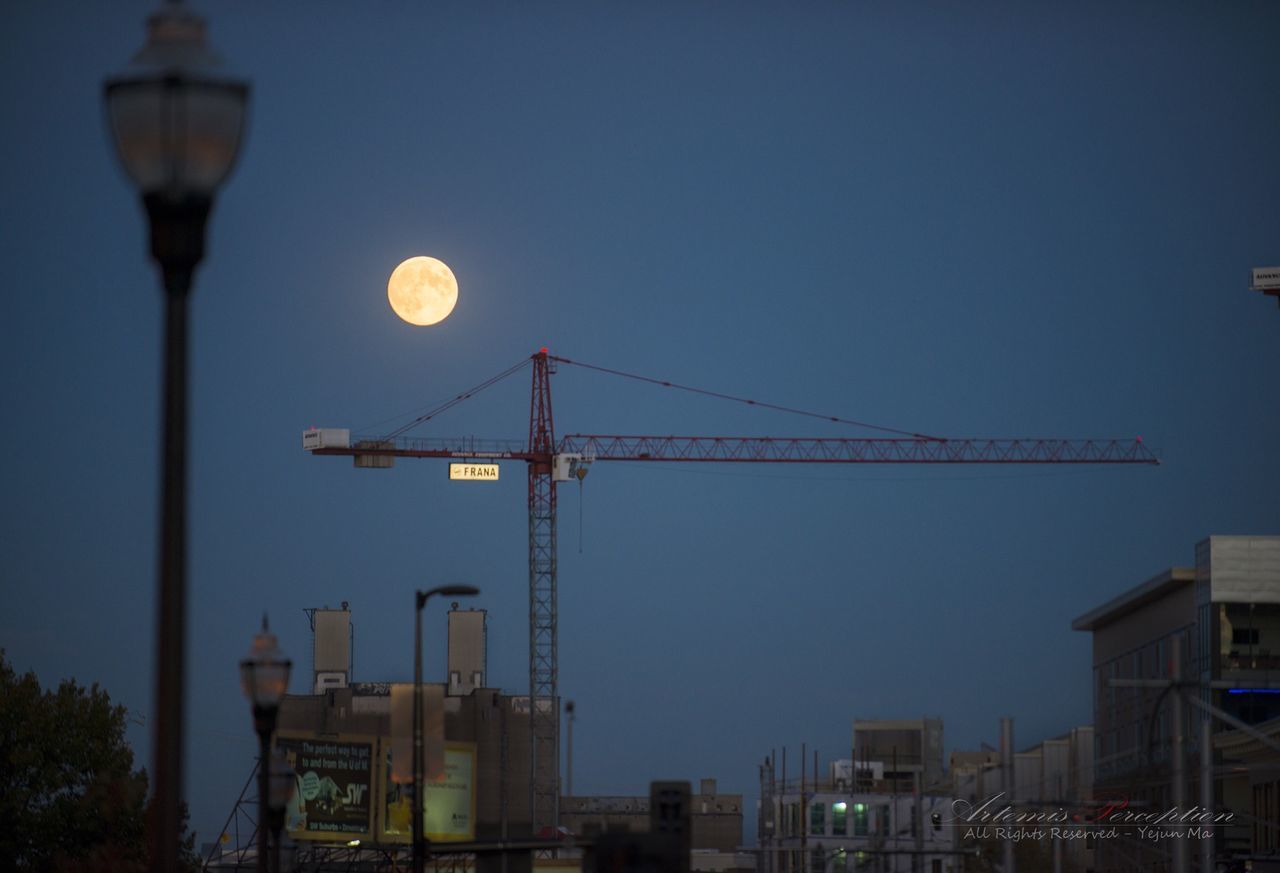 built structure, building exterior, architecture, clear sky, low angle view, street light, illuminated, lighting equipment, copy space, city, night, moon, crane - construction machinery, communication, sky, communications tower, dusk, tower, development, outdoors