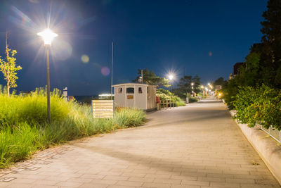 Street amidst buildings against sky at night