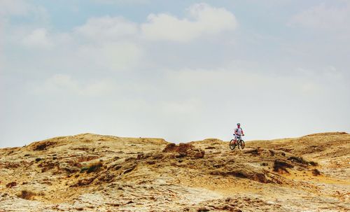 Rear view of man standing on landscape against sky