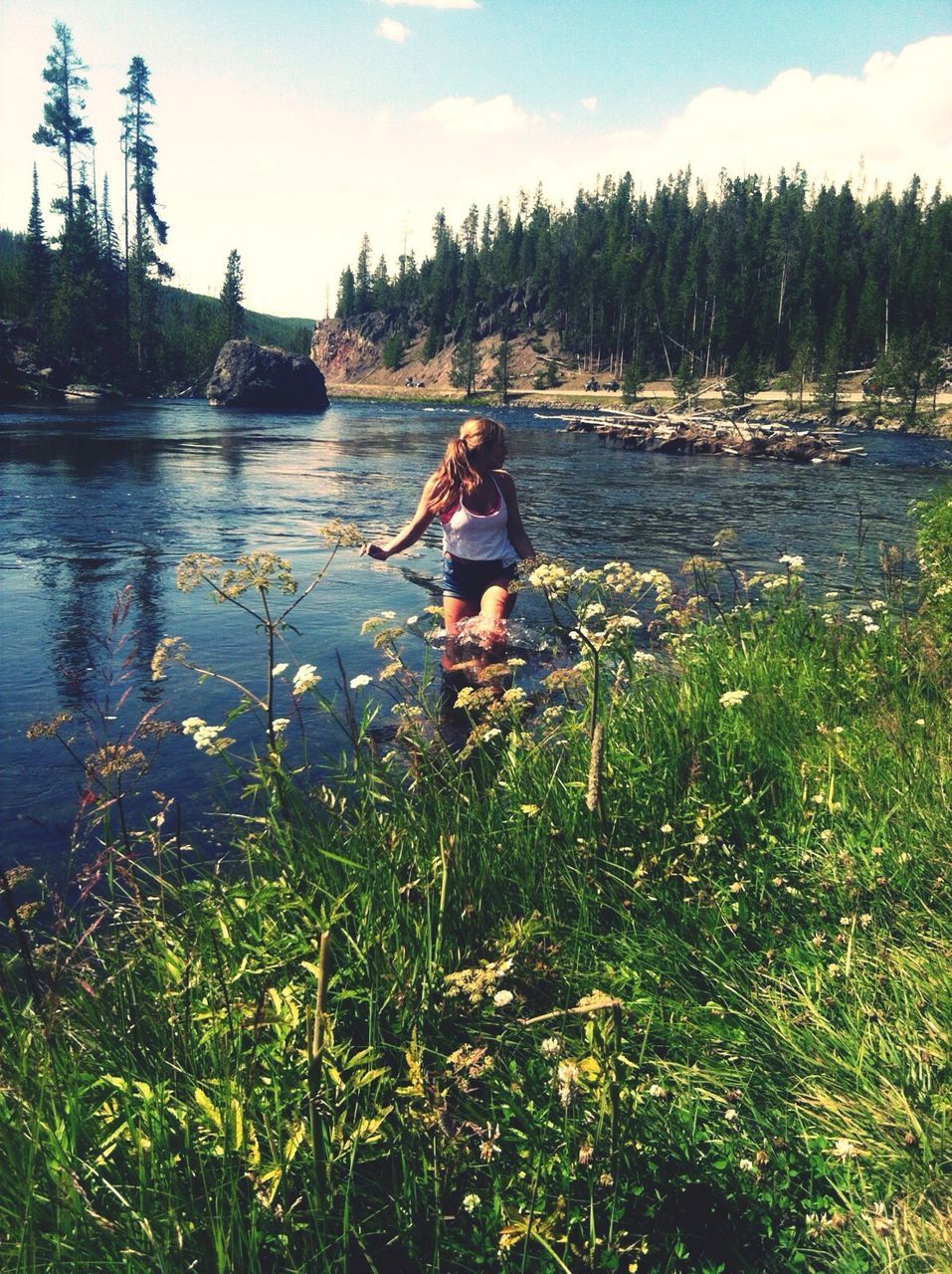 water, lifestyles, leisure activity, full length, casual clothing, young adult, lake, sky, person, standing, nature, plant, tranquility, tree, young women, grass, beauty in nature, rear view