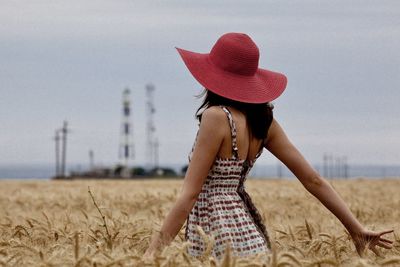 Midsection of woman standing on field against sky