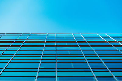 Low angle view of modern building against clear blue sky