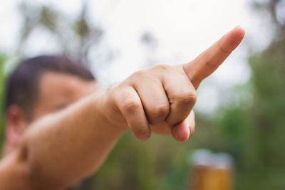 Close-up of man hand pointing in park