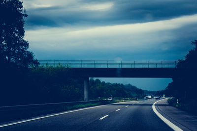 Bridge over river against cloudy sky