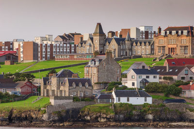 Buildings in city against clear sky
