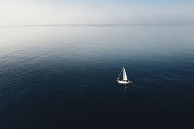 Sailboat sailing on sea against sky