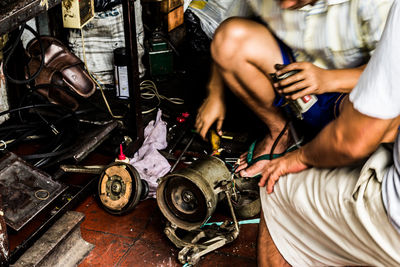 Low section of man working on motorcycle