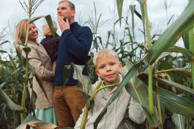Family walking in corn field at autumn