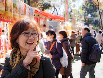 An older japanese woman smiling at a festival