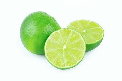 Close-up of green fruit against white background