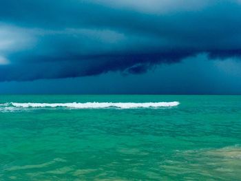 Scenic view of sea against storm clouds