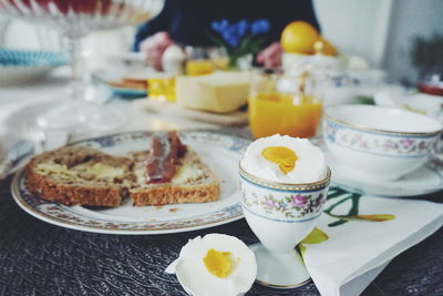 Close-up of boiled egg and sandwich on place mat at dining table