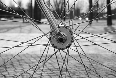 Close-up of bicycle spokes on footpath