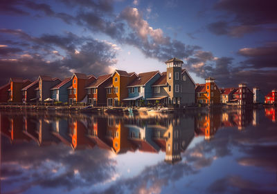 Reflection of buildings in city at sunset