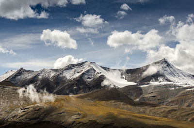 Scenic view of mountain range against cloudy sky 