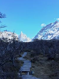 Scenic view of snowcapped mountains against clear blue sky