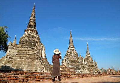 Female tourist visiting pagoda ruins of wat phra si sanphet in ayutthaya historical park, thailand