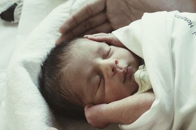 Close-up of baby sleeping on bed