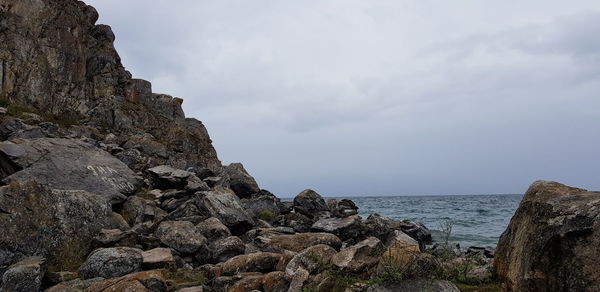 Rock formation on beach against sky