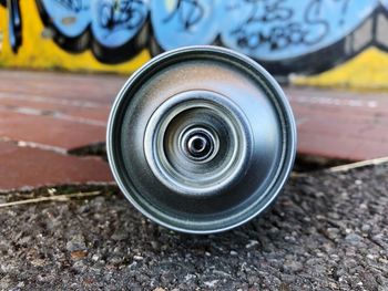 Aerosol can on road against graffiti wall