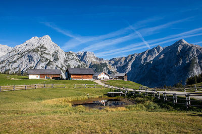 Built structure on field by mountain against sky