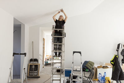 Female electrician renovating house