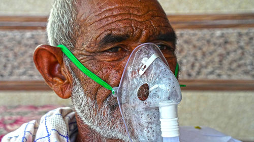 Close-up portrait of man wearing oxygen mask