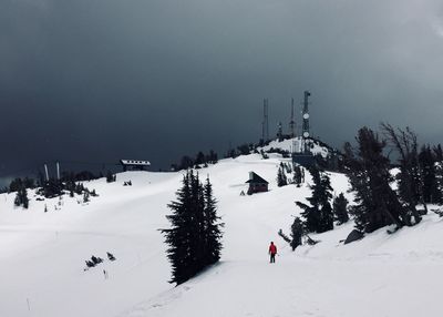 People skiing on snow covered land against sky