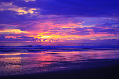 Scenic view of beach against cloudy sky