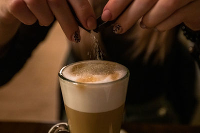 Girl pouring sugar into coffee