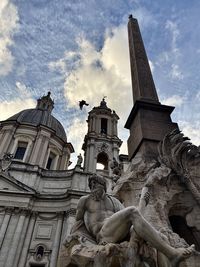 Low angle view of statues on building against sky