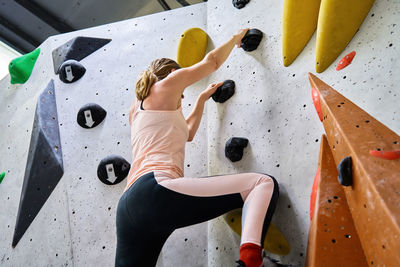 Woman training at bouldering gym. active recreation, sports exercises