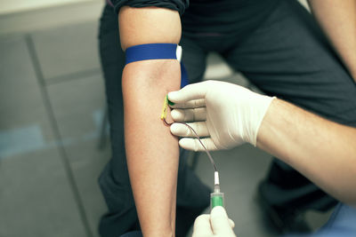 Cropped image of doctor injecting iv drip needle