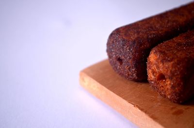 Close-up of bread on table against white background