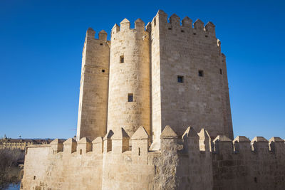 Low angle view of old ruins against clear blue sky