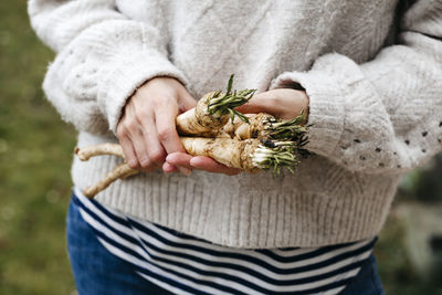 Midsection of woman holding radish