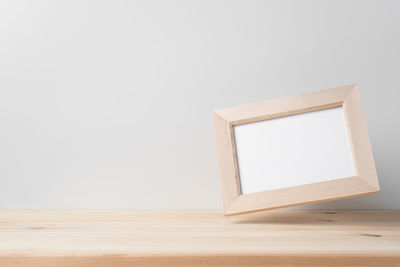 Low angle view of empty wooden railing against white background