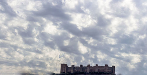 Low angle view of buildings against cloudy sky