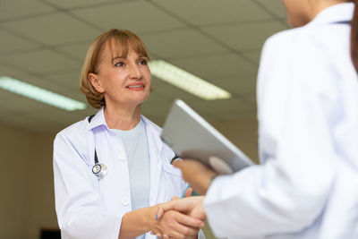 Portrait of smiling female doctor examining patient in hospital