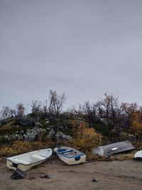 Boats moored on shore against sky