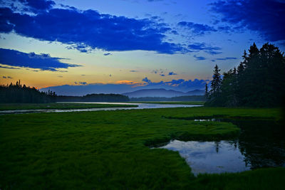 Scenic view of river against cloudy sky