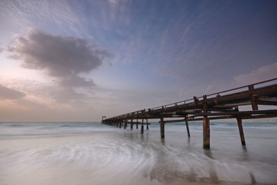 Pier over sea against sky during sunset