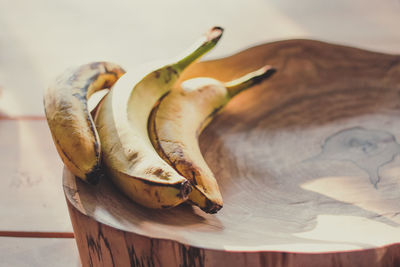 Close up ripe bananas lying on wooden stump under sunlight concept photo