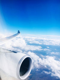 Airplane flying over clouds against blue sky