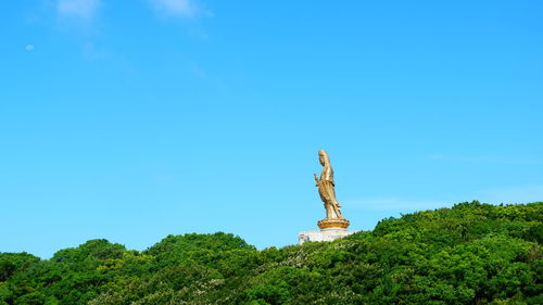 Low angle view of statue against clear blue sky