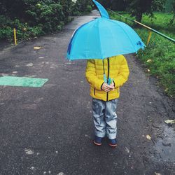 Rear view of man walking on wet street