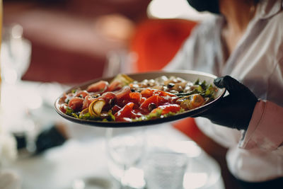 Midsection of woman preparing food in restaurant