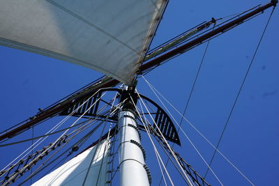 Low angle view of sailboat against clear blue sky