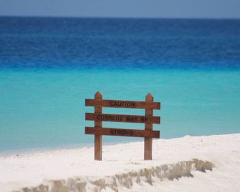 Wooden signboard by sea